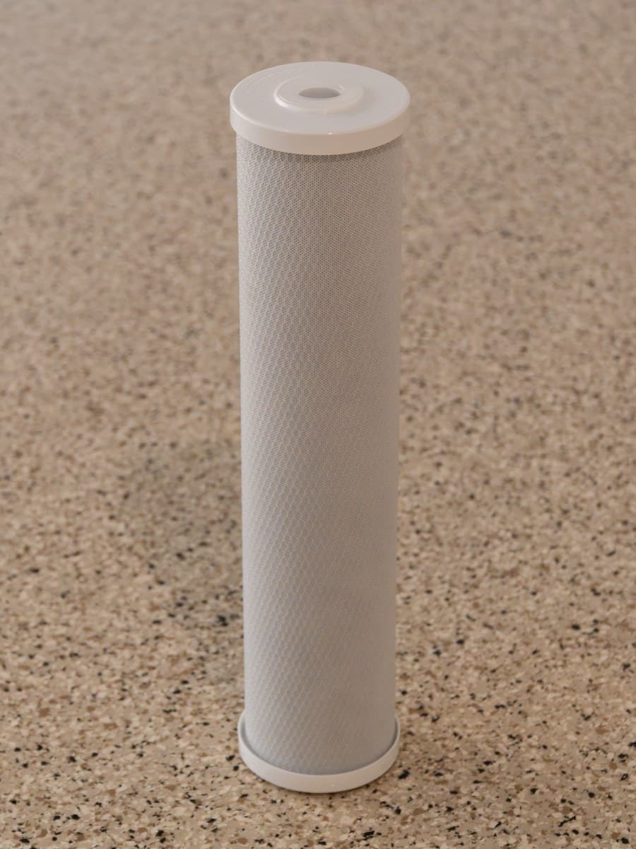 The coconut-shell carbon cartridge: a dense carbon block wrapped in a fine mesh sleeve.